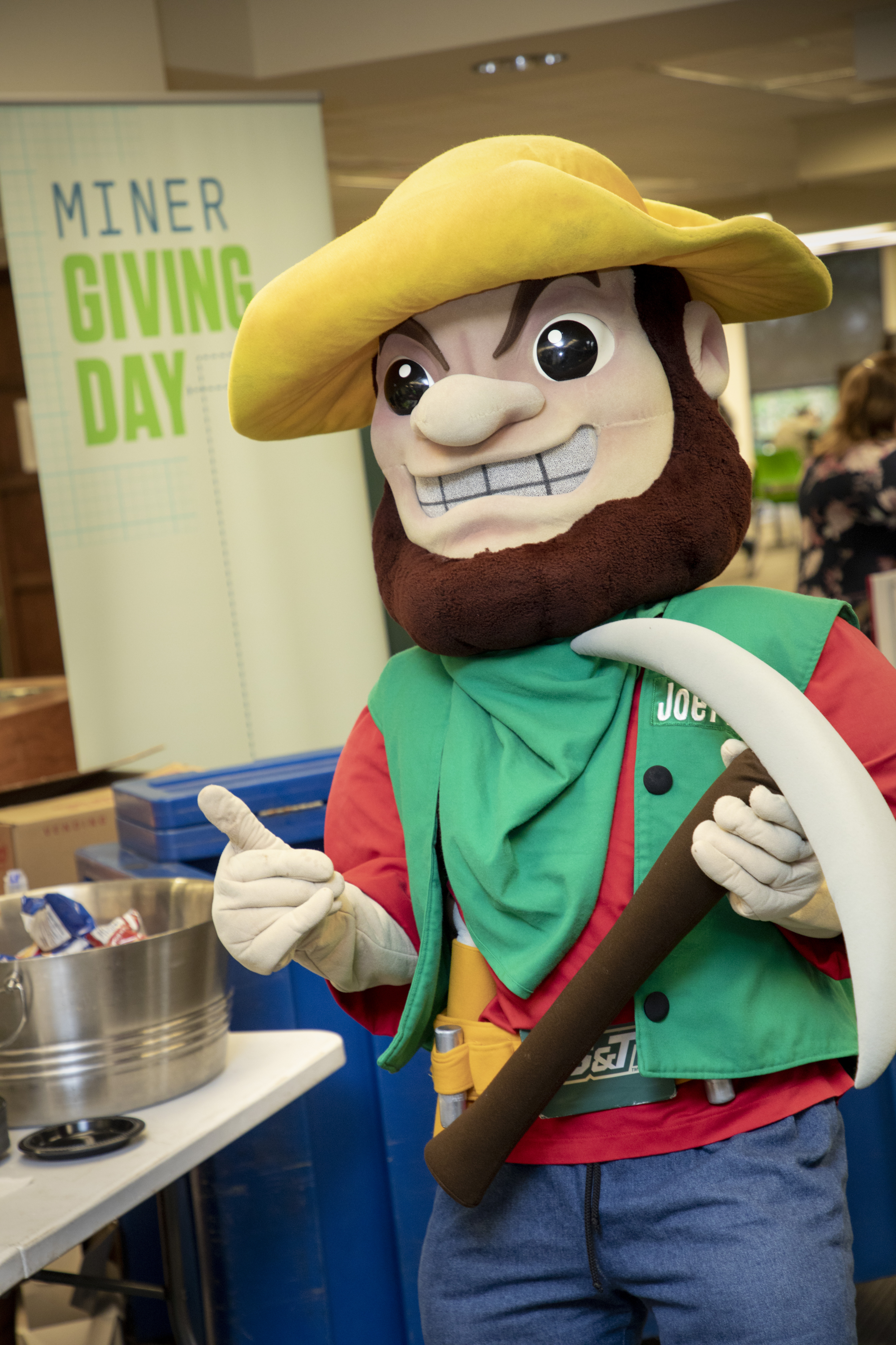 Picture of Joe Miner in front of Miner Giving Day sign
